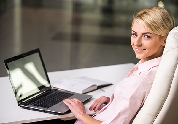 Side view of smiling businesswoman is working at office.