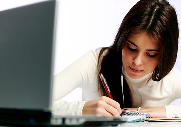 Young thoughtful student doing her homework